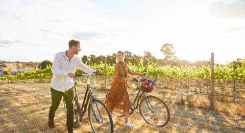 夫妇在克洛纳基拉酒庄 (Clonakilla Wines) 周围骑自行车 葡萄园 位于穆任百特曼