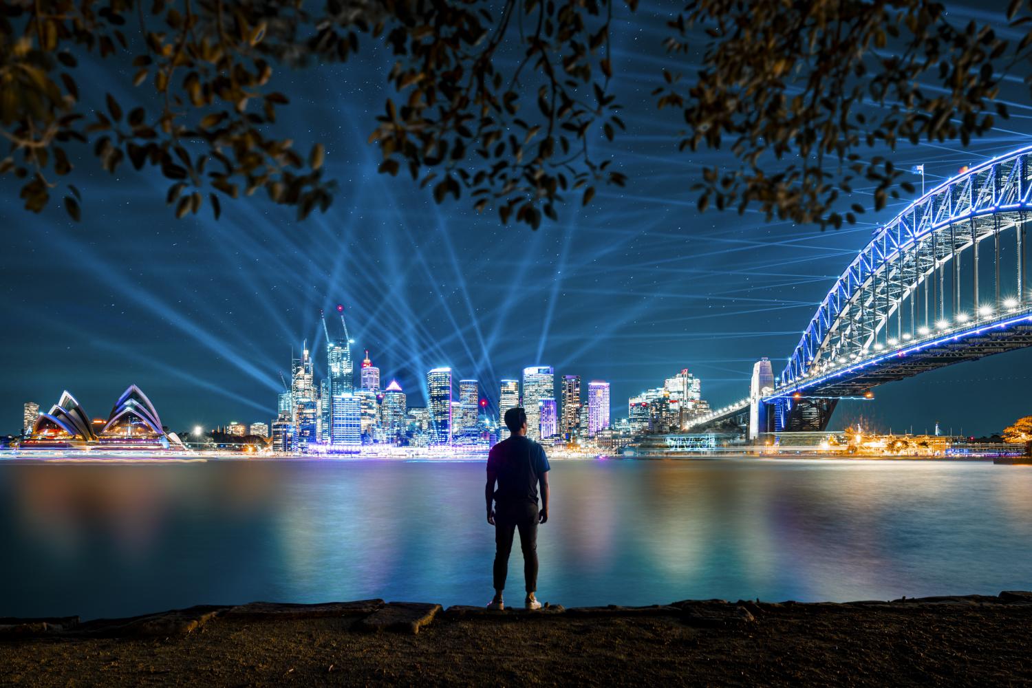 男子看着城市的灯光投影和安装在悉尼海港大桥从基里比利缤纷悉尼灯光音乐节